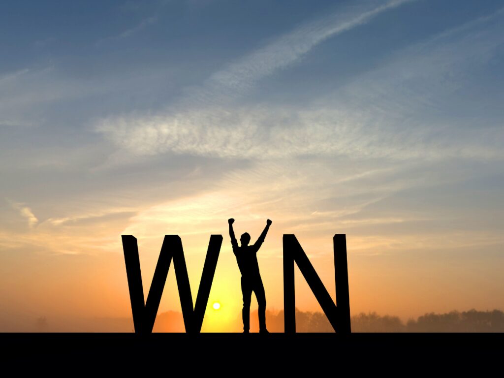The words WIN with the I being a person raising arms in victory