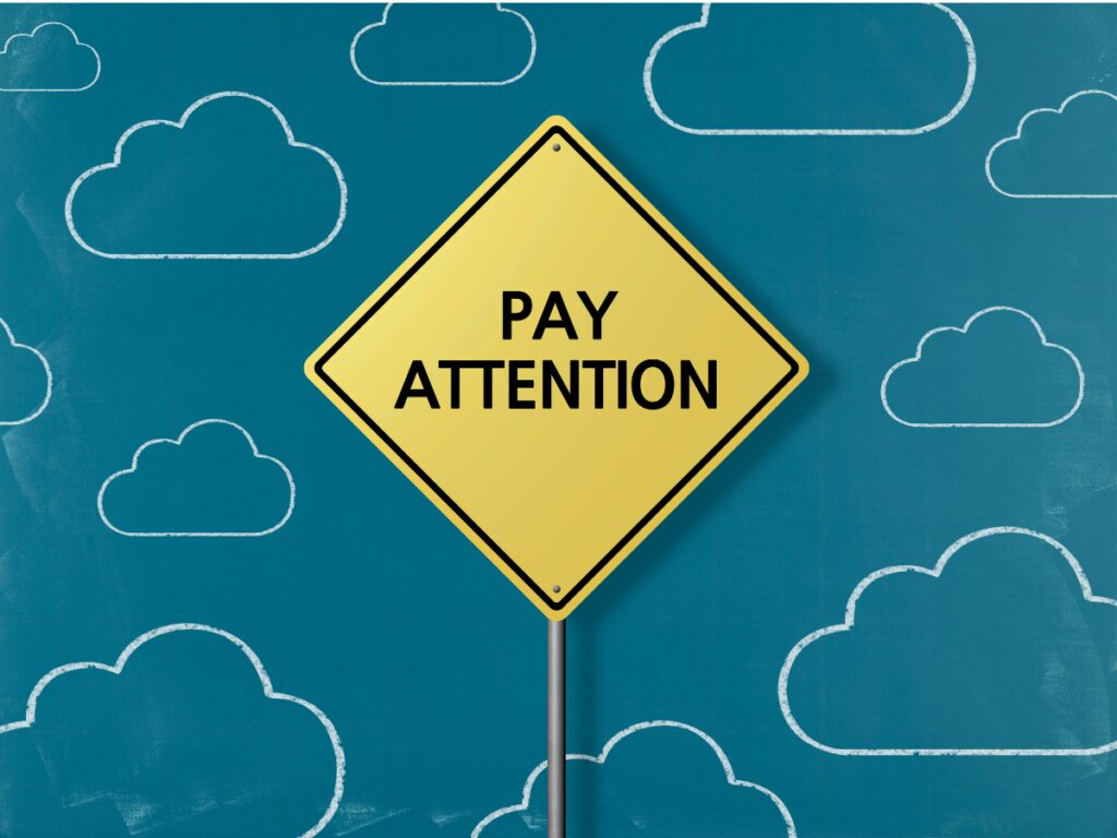 Yellow sign saying Pay Attention